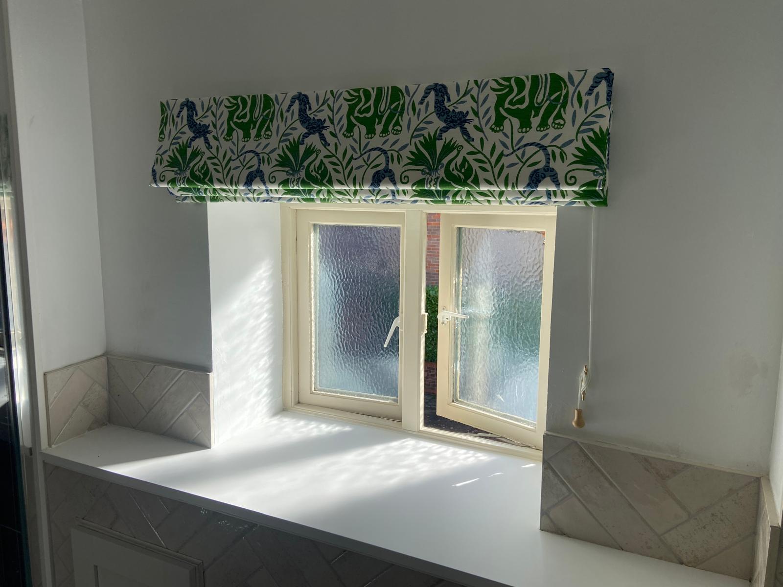 Green elephant and jungle print Roman blind above a window seat