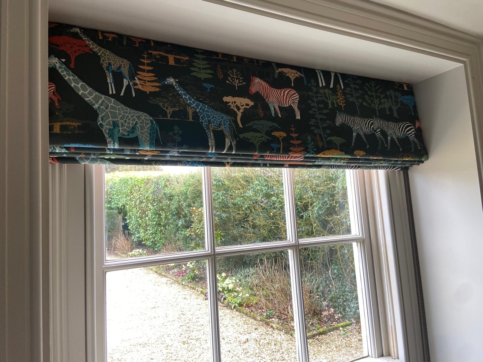 Close-up of safari print Roman blind with giraffes and zebras