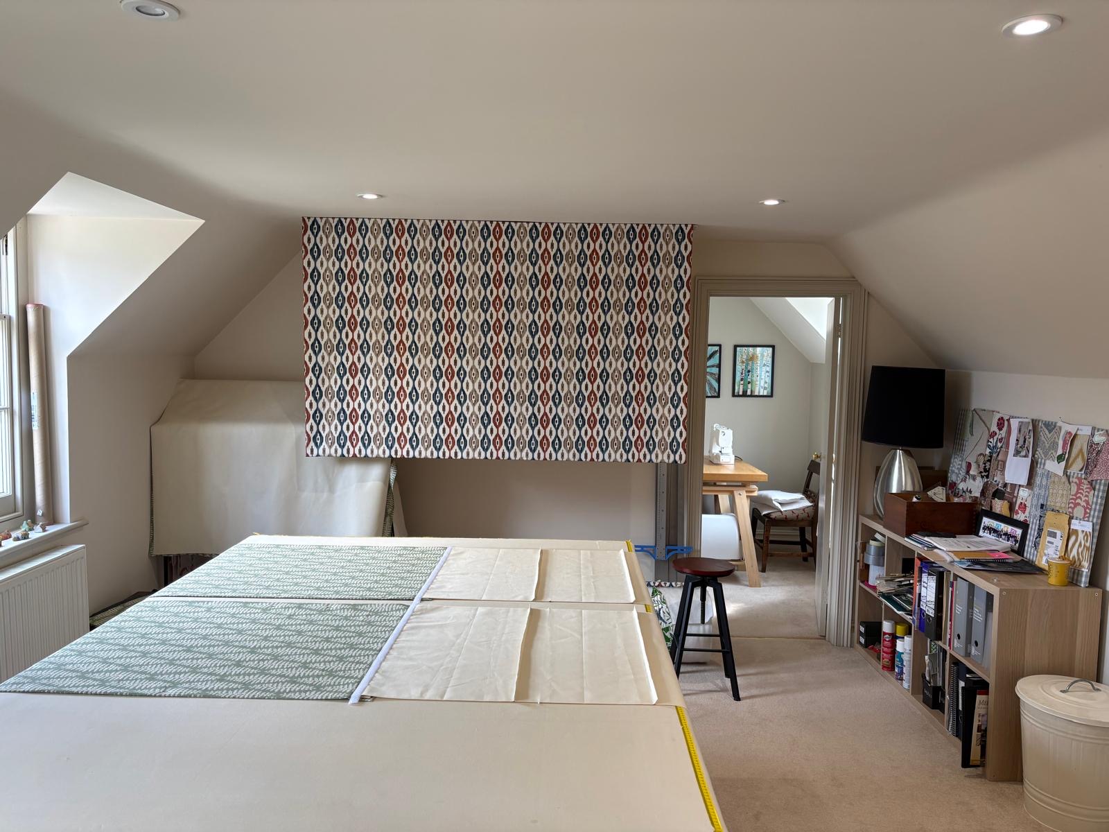 Anna's Hampshire workroom with cutting table, sewing machine and fabric samples