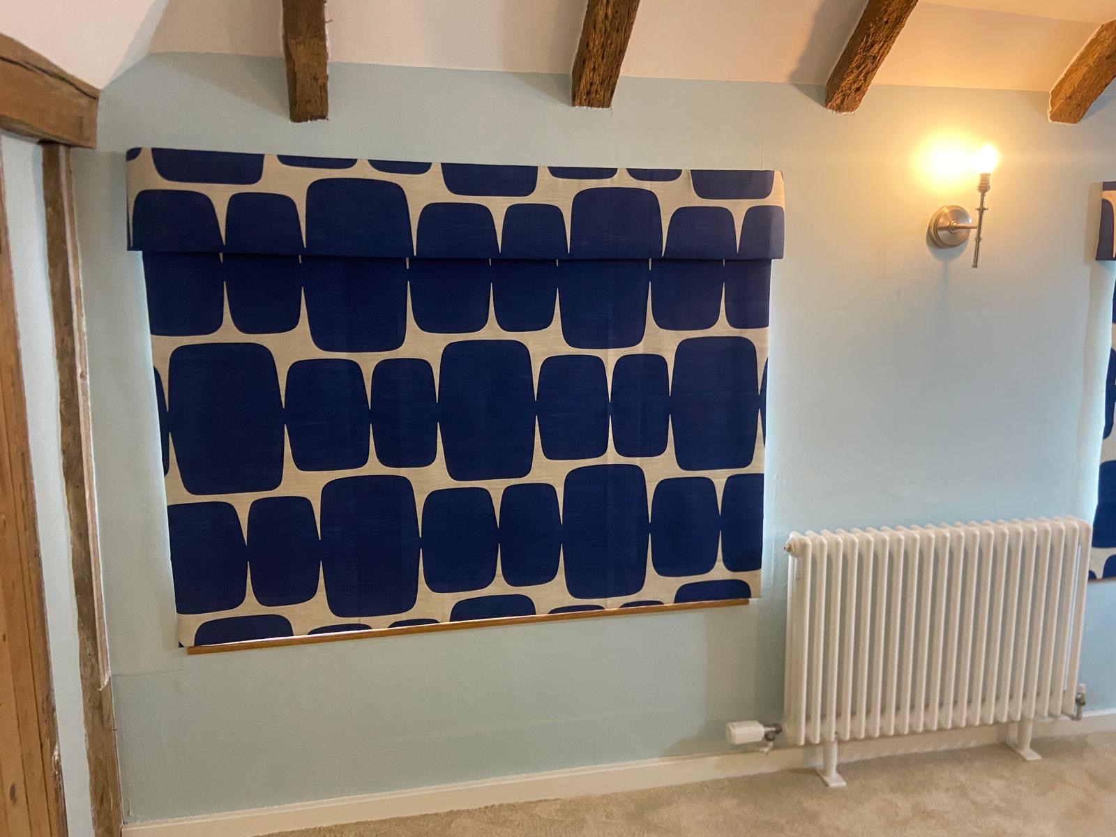 Bold blue patterned Roman blind with pelmet in a beamed room