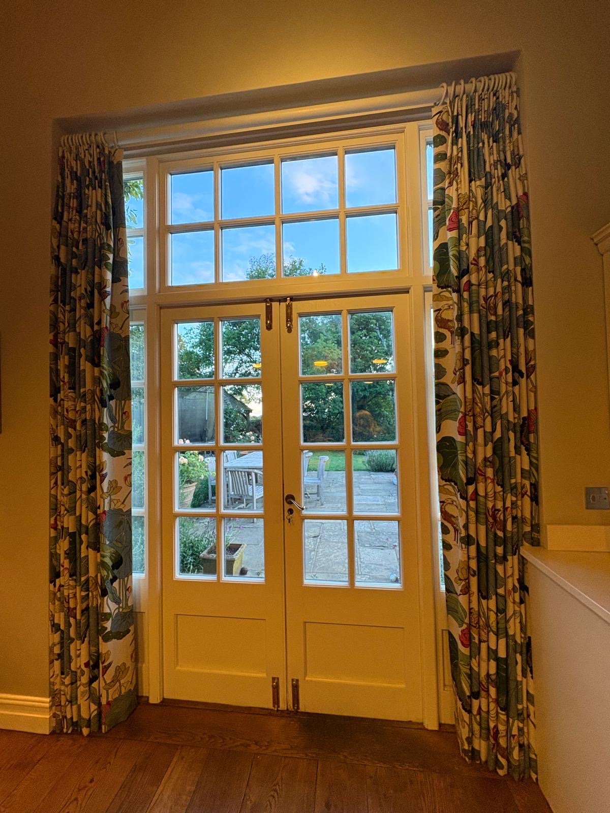 Floor-length floral curtains at tall French windows