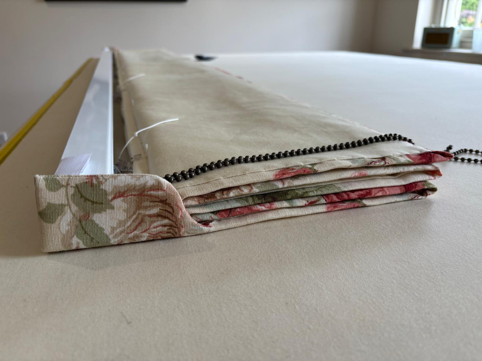 Rose floral Roman blind folded on the workroom table