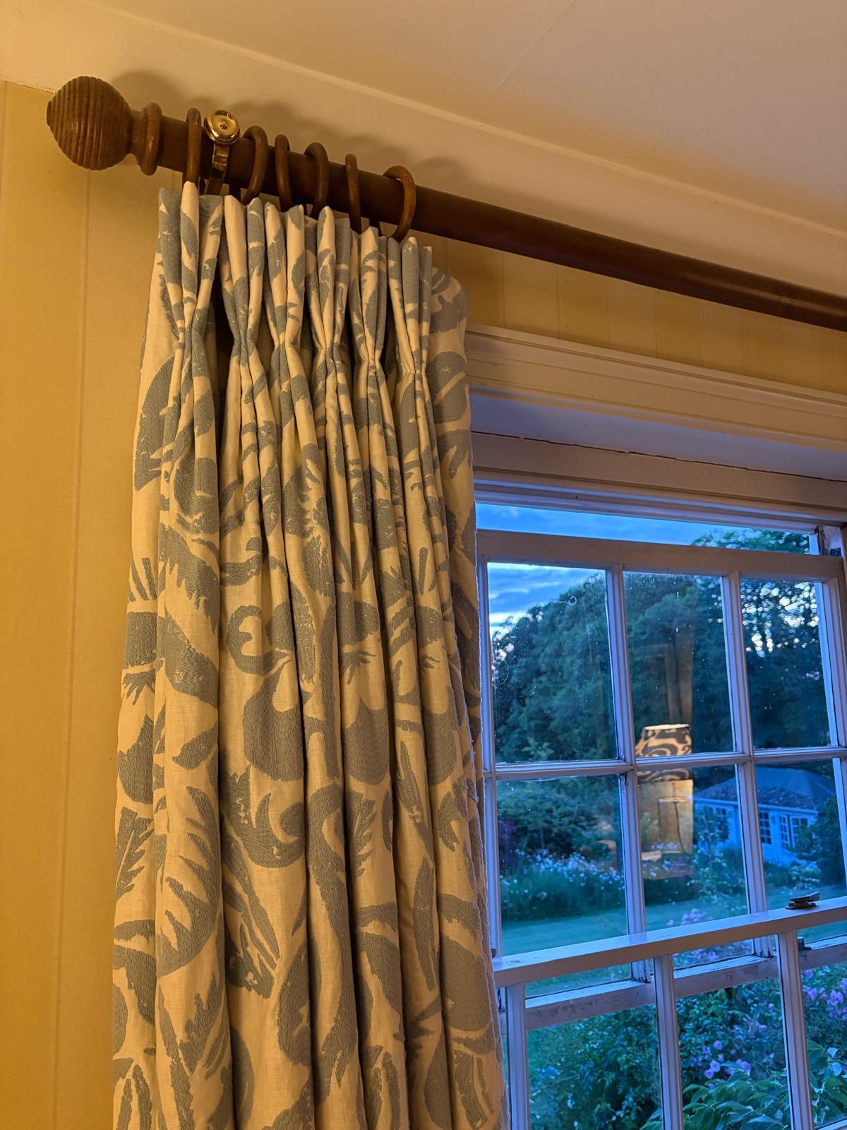 Blue and cream botanical print pinch pleat curtains on a wooden pole