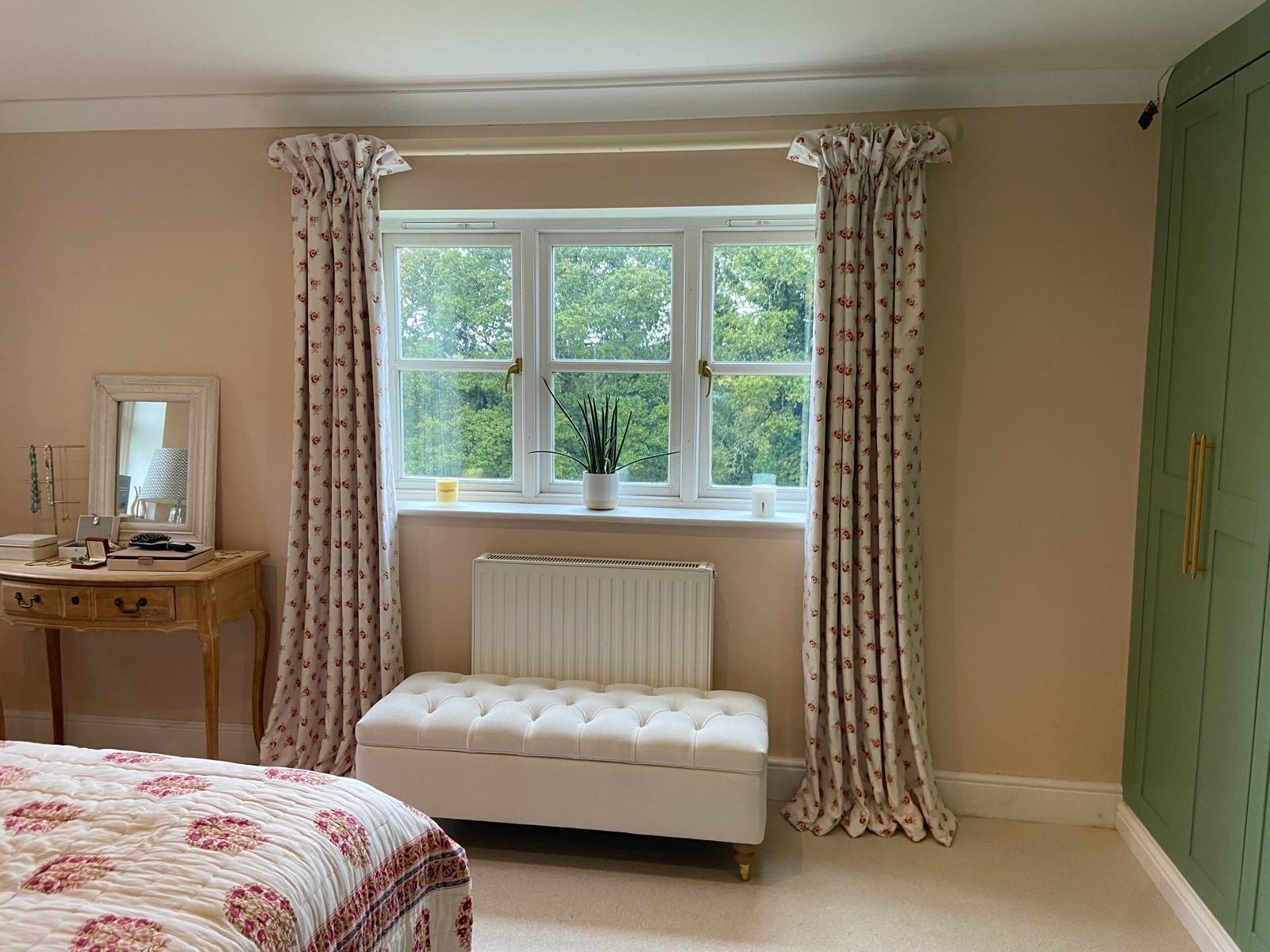 Rose-sprig pencil pleat curtains in a soft pink bedroom